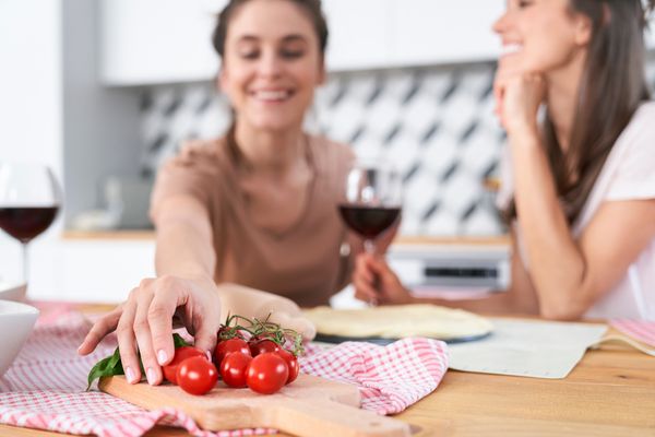 Freundinnen snacken beim Gespräch Bio-Tomaten